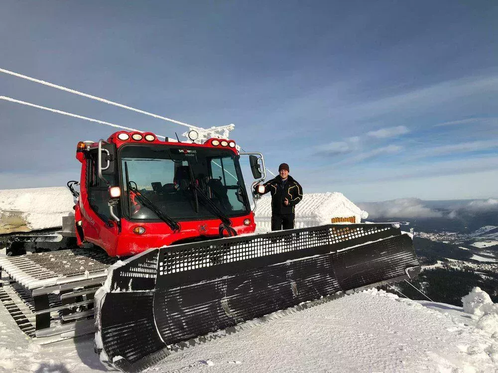 Stefan Beywl next to a PistenBully