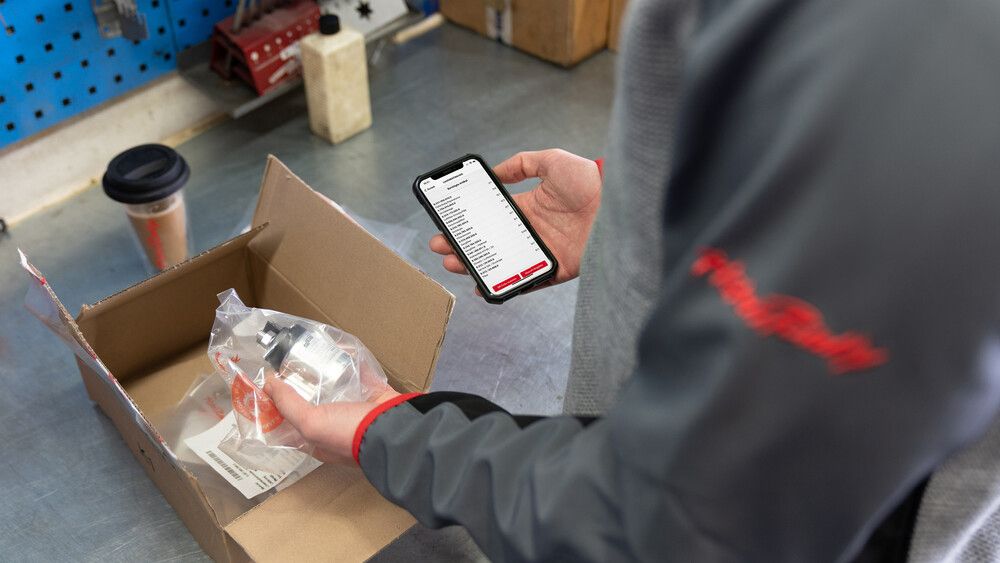 SNOWsat Maintain | Smartphone Eine Person bedient SNOWsat Maintain am Smartphone.
