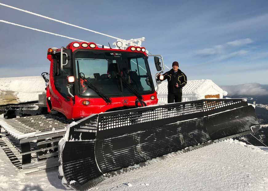 Stefan Beywl à côté d'un PistenBully